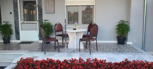 a table and chairs in front of a house with flowers at Kariofilli's house in Áyios Athanásios