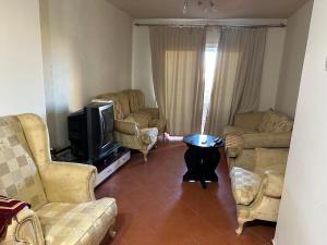 a living room with couches and a flat screen tv at جولف بورتو مارينا in El Alamein