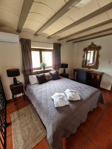 a bedroom with a large bed with two towels on it at Masia Cal Lloa in Albinyana +35 photos