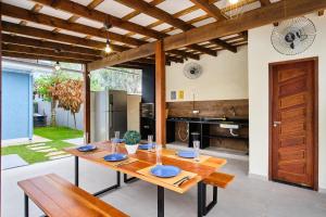 a dining room with a table and a kitchen at Casa Caminho da Praia 3 quartos com ar no Cabore in Paraty