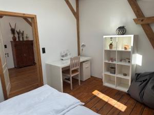 Schlafzimmer mit einem Schreibtisch, einem Bett und einem Tisch in der Unterkunft Urlaub in Einer Historischen Wassermühle an der Trave in Lübeck