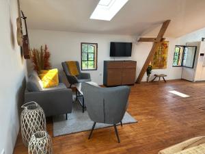 ein Wohnzimmer mit Sofa, Sesseln und Fernseher in der Unterkunft Urlaub in Einer Historischen Wassermühle an der Trave in Lübeck