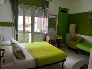 1 dormitorio con paredes verdes, 1 cama y ventana en Lo Statere d' Argento, en Caulonia Marina