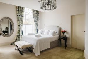 a bedroom with a large white bed and a mirror at Grand Historical Listed energy efficient retreat Canterbury completely modernised in Canterbury