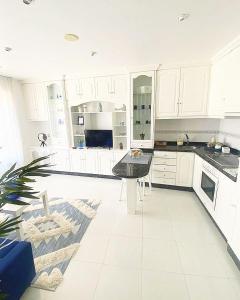 a kitchen with white cabinets and a black counter top at Apartamento San Roque in Betanzos