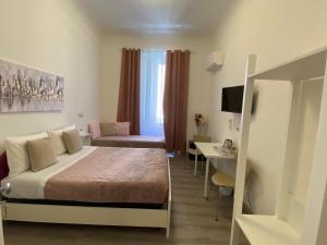 a hotel room with a bed and a desk at Titi Rooms in La Spezia