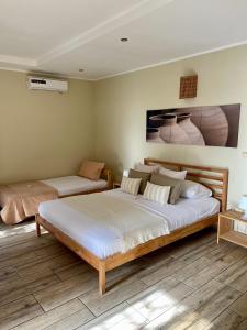 a bedroom with two beds and a painting on the wall at 21 Palms in Las Galeras