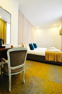 um quarto com uma cama, uma cadeira e uma secretária em Heritage Hotel Petrakija em Saraievo