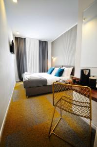 um quarto de hotel com uma cama e uma cadeira em Heritage Hotel Petrakija em Saraievo