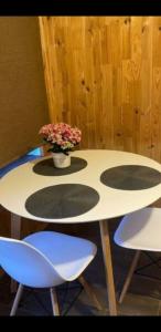 un tavolo con due sedie e un vaso con dei fiori sopra di Lauku street private apartment a Liepāja