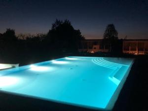 a swimming pool lit up at night with blue lights at Agricamping Zanina 9 in Peschiera del Garda