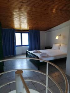 - une chambre avec un grand lit et des rideaux bleus dans l'établissement Angistri's panorama apartments, à Skala