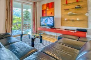 a living room with a couch and a tv at Apartment Leon - by Alpen Apartments in Zell am See