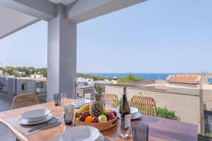 - une table avec un bol de fruits et une bouteille de vin dans l'établissement Leon Luxury Home in Rethymno, à Gállos