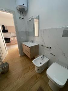 La salle de bains est pourvue de toilettes blanches et d'un lavabo. dans l'établissement U Curtigliu apartment, à Realmonte