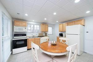 a kitchen with a wooden table and a white refrigerator at Jackson River Estate Cozy Cottage on the River in Covington