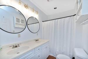 une salle de bain blanche avec un lavabo et un miroir dans l'établissement Jackson River Estate Cozy Cottage on the River, à Covington 31 autres photos