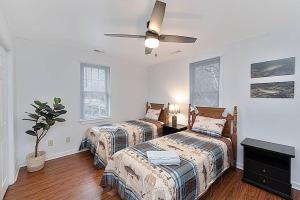 1 dormitorio con 2 camas y ventilador de techo en Jackson River Estate Cozy Cottage on the River, en Covington