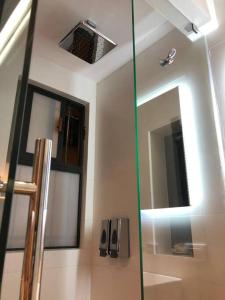 a bathroom with a glass shower with a mirror at Low level cozy independent suite in Roma Norte in Mexico City