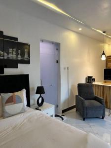a bedroom with a bed and a chair at MCM _Haven in Dar es Salaam