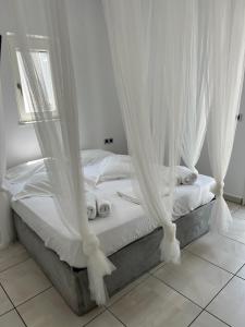 アンティパロス・タウンにあるLa scalaの白いカーテン付きのベッド1台