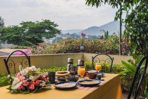 una mesa con platos de comida y bebidas. en Aparthotel Jardin Tropical en Buyumbura