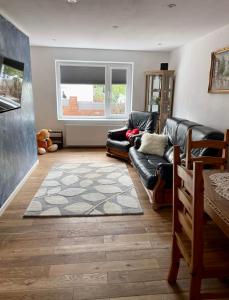 uma sala de estar com um sofá de couro preto e uma janela em Adina s House em Rugeley