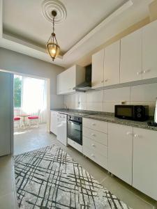 una cucina con armadi bianchi e un tappeto sul pavimento di Kesik Apart a Antalya (Adalia)