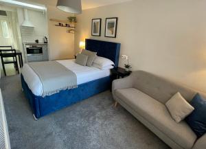 ein Schlafzimmer mit einem Bett und einem Sofa in der Unterkunft Cannock Hotel Apartments in Cannock