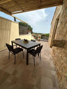 un tavolo e sedie seduti su un patio di Borgo Monachella a Ragusa