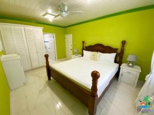 ein Schlafzimmer mit einem großen Bett mit grünen Wänden in der Unterkunft EHL Calypso Villa 4Bed 4.5baths, 5min to Beach in Saint Philip