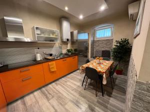 a kitchen with a table and a kitchen with orange cabinets at Casa Vacanza Ginevra in Genoa