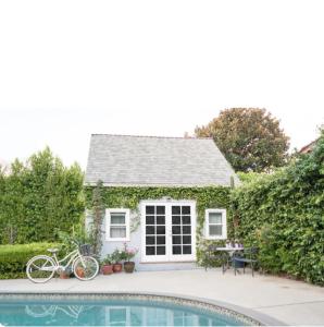 a house with a bike parked next to a swimming pool at English Cottage Guest House walk to the Grove and lots of attractions in Los Angeles