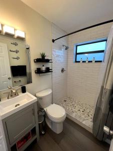 uma casa de banho com um WC, um lavatório e um chuveiro em Modern Tropical Oasis with Arcade, HotTub & MiniGolf em Hollywood