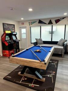 a pool table in a living room with a pool table at Modern Tropical Oasis with Arcade, HotTub & MiniGolf in Hollywood
