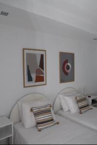 biały salon z dwoma białymi kanapami i zdjęciami w obiekcie Fiosal Apartments 2 w mieście Skiatos