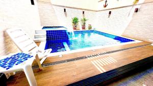 a swimming pool in the middle of a house at Piscina com ofurô/Churrasqueira/Sinuca e Ping Pong in Caraguatatuba