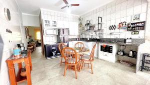 a kitchen with a table and chairs in it at Piscina com ofurô/Churrasqueira/Sinuca e Ping Pong in Caraguatatuba