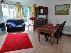 een woonkamer met een houten tafel en een rood tapijt bij Kop vd Hondsrug1 in Haren