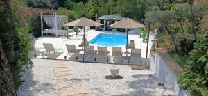 a swimming pool with chairs and umbrellas in a yard at Masia CM Costa Brava in Santa Pellaya