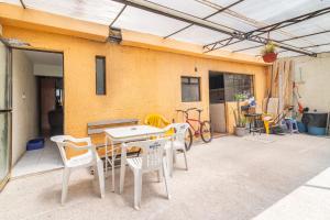 un patio con tavolo, sedie e un edificio di Acogedora habitación doble a 5 min del Aeropuerto CDMX a Città del Messico
