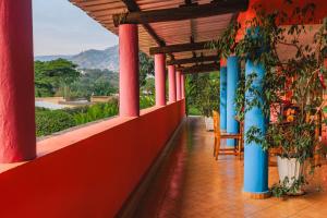 un pasillo de una casa con columnas rojas y azules en Aparthotel Jardin Tropical en Buyumbura