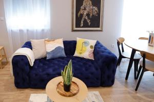 Sofá azul en la sala de estar con mesa en Treetop Apartments en Vršac