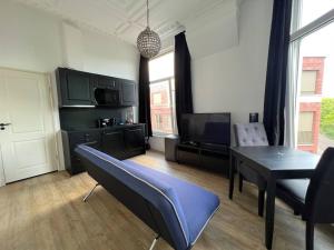 a living room with a table and chairs and a tv at Rotterdam Inn in Rotterdam
