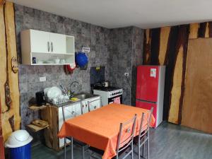 a small kitchen with a table and a red refrigerator at Cabaña cunco 6 personas in Cunco