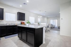 a kitchen with black cabinets and a living room at MM house in Marana