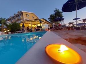 a yellow candle sitting next to a swimming pool at Hotel Piccolo Mondo in Acquappesa