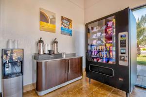 a refrigerator next to a counter with drinks in it at Motel 6-Santa Nella, CA - Los Banos in Santa Nella Village