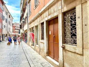 a group of people walking down a street at Romeo apartments Rovigno in Rovinj