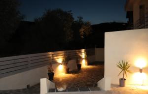 a patio with potted plants and lights at night at Fiosal Apartments 2 in Skiathos Town